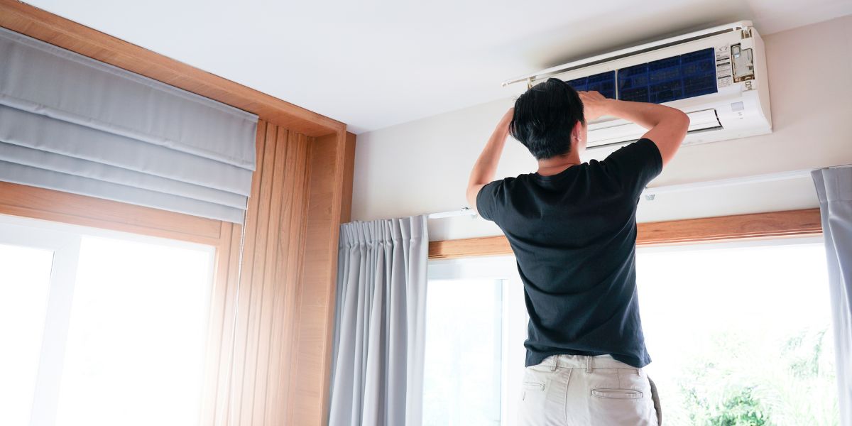 Technician man repairing, cleaning and maintenance air conditioner